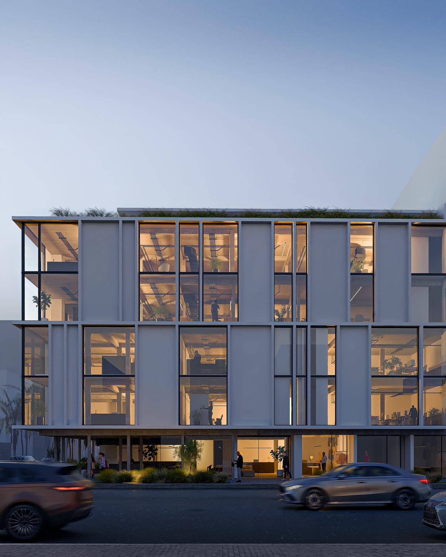 Render arquitectónico de Urban Covadonga al atardecer, con las plantas de oficinas iluminadas tras el vidriado perimetral