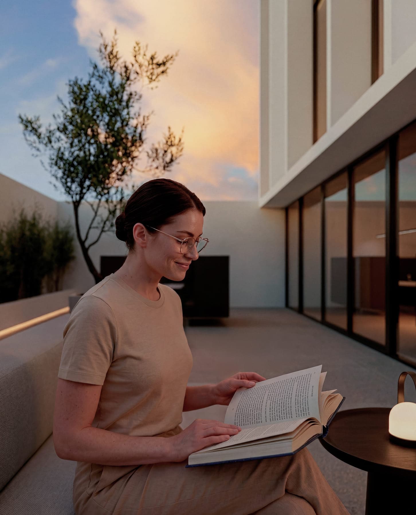 Mujer leyendo un libro en el sector lounge del rooftop al atardecer